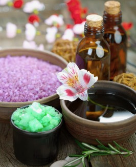 Aromatherapy supplies: two bottles, purple salts, flower floating in water | How to use essential oils