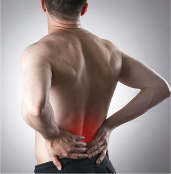 Man with hands on lower back, indicating  pain.