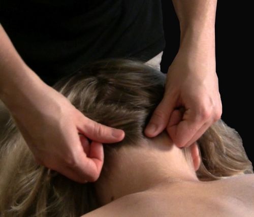 Neck massage on the back of a woman's neck.