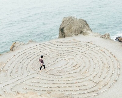 spiritual labyrinth Person walking labyrinth on a beach as a spiritual practice.