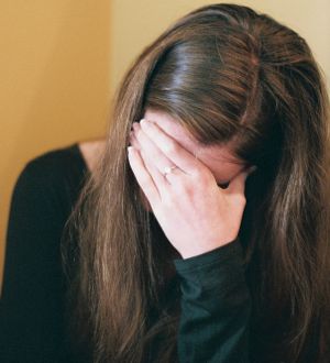 Depressed woman with hand on face